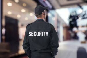 Security guard overlooking an urban area with tall buildings and trees.