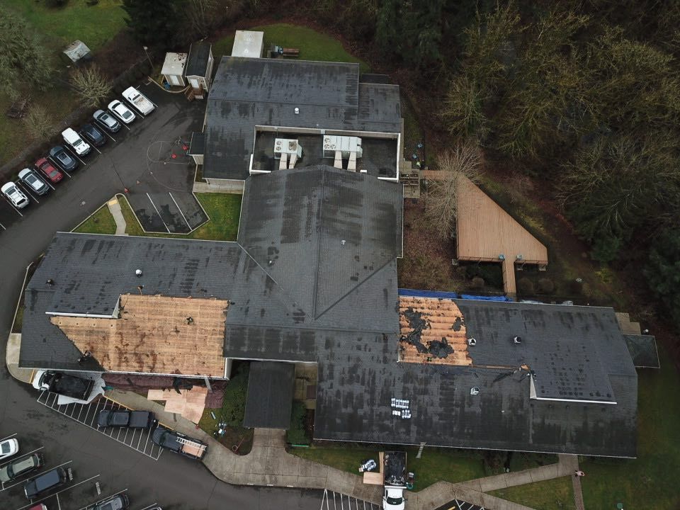 An aerial view of a building with a roof that is being repaired
