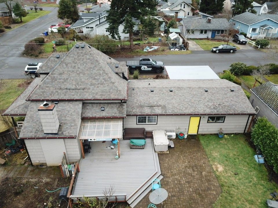 An aerial view of a house with a deck and a truck parked in front of it.