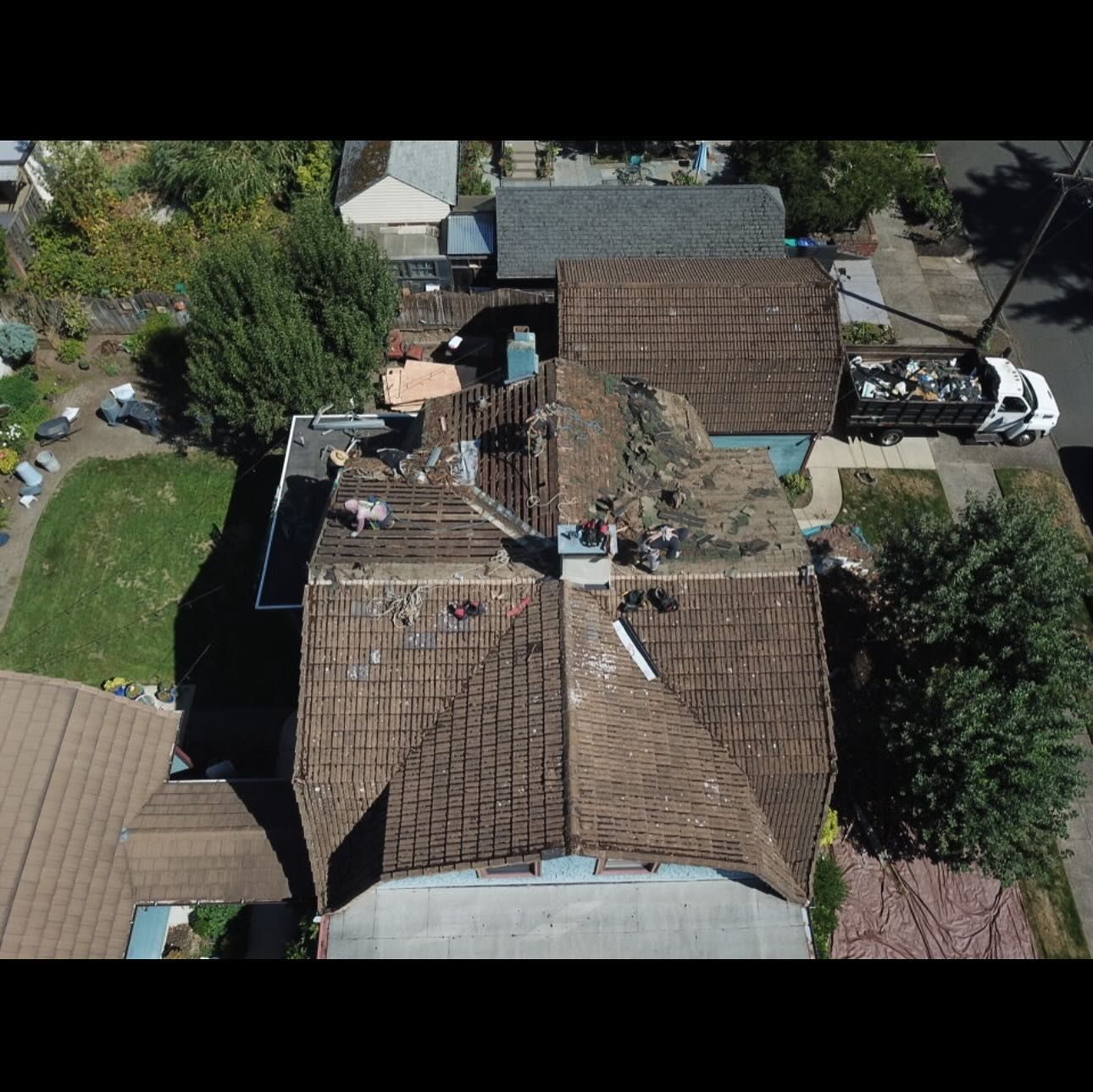 An aerial view of a house with a roof that is being repaired.