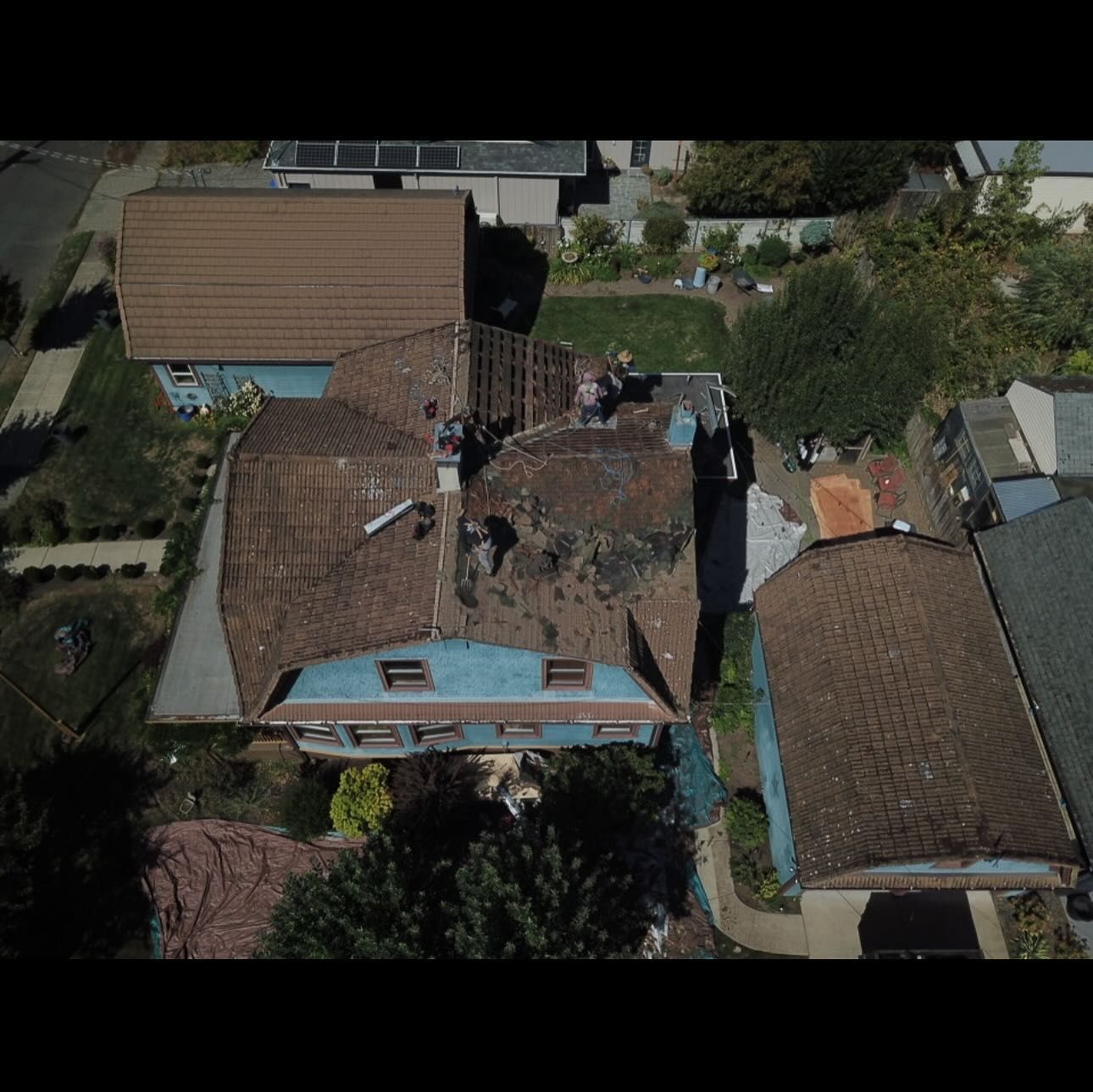 An aerial view of a house with a roof that has been damaged by a fire.
