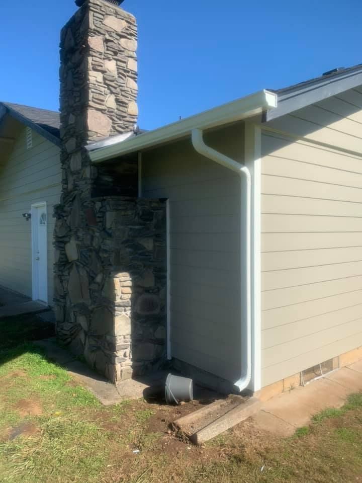 A house with a chimney and a gutter on the side of it.