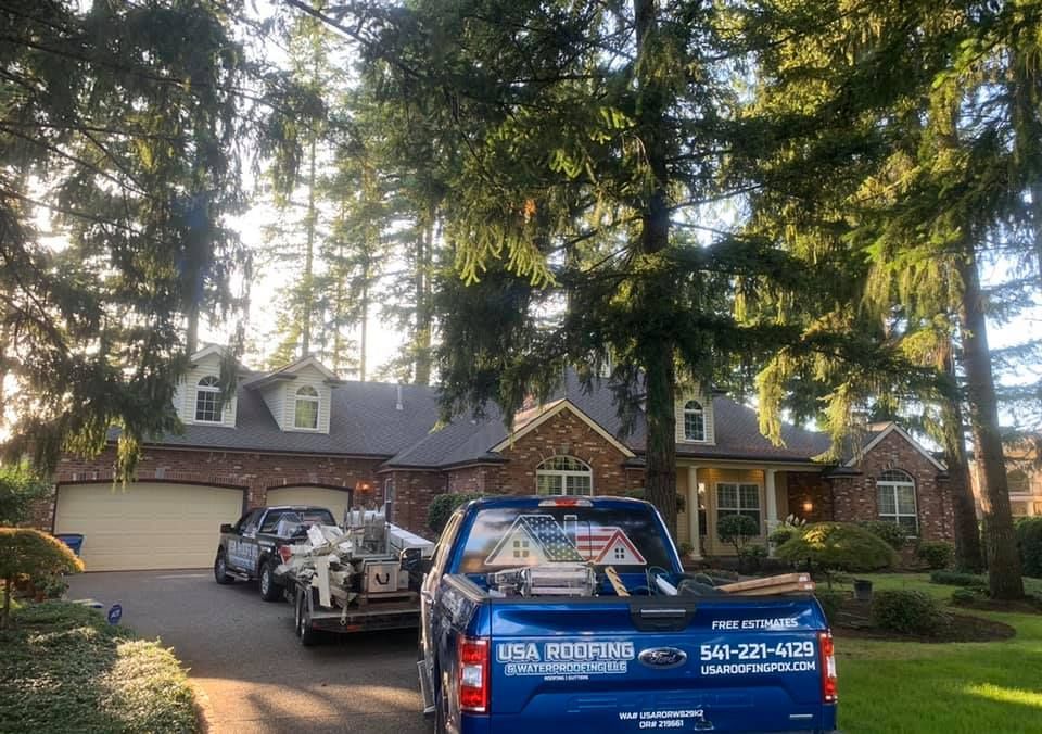 A blue truck is parked in front of a brick house.