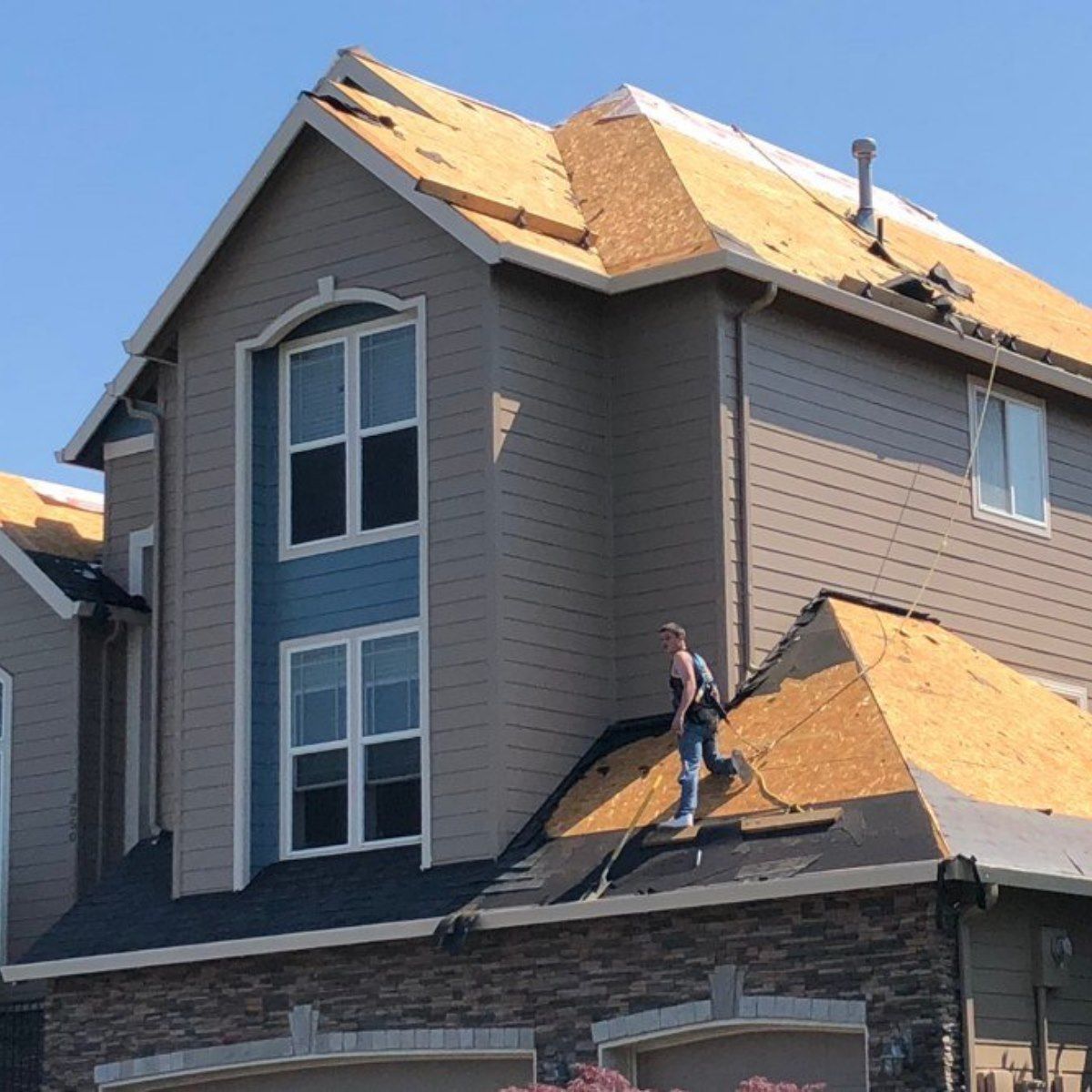 A man is working on the roof of a house.