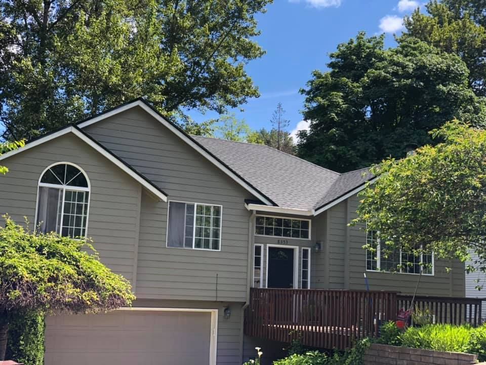 A large house with a gray siding and a gray roof.