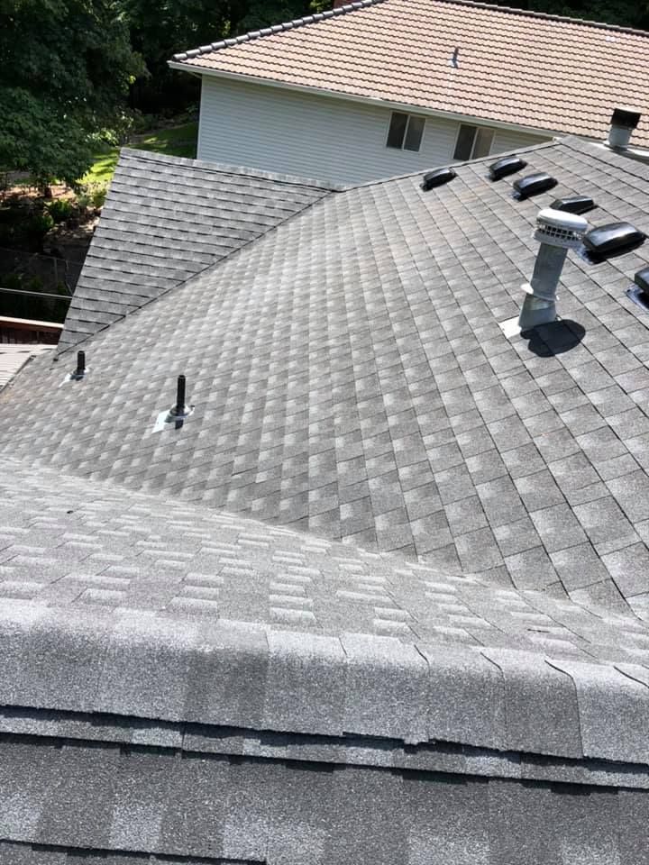 A roof with a lot of shingles and a chimney on it.