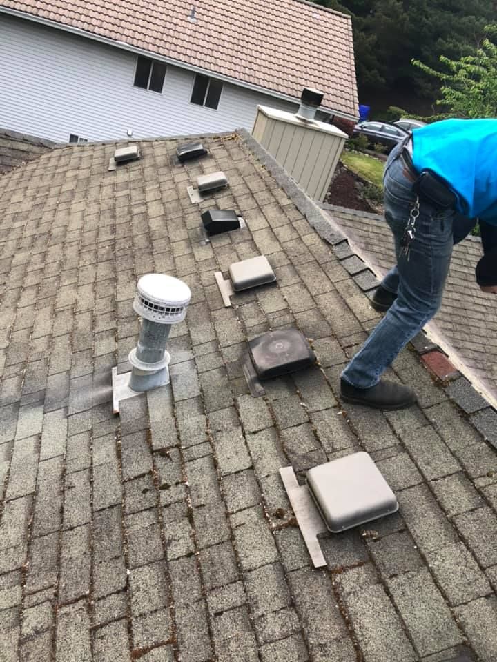 A man is working on the roof of a house.