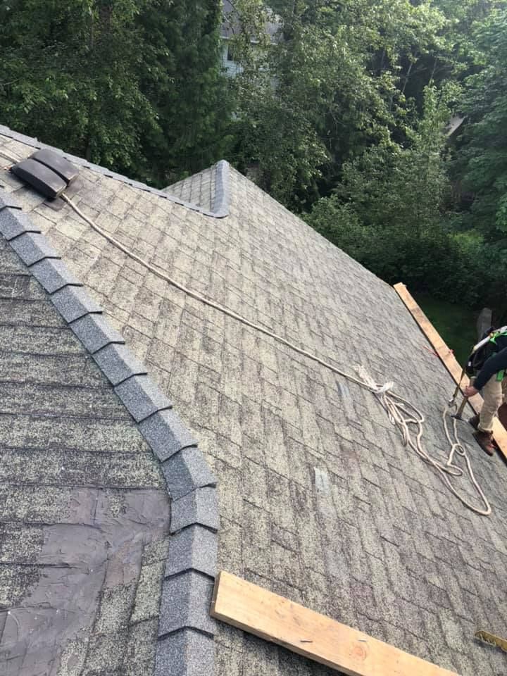 A man is working on the roof of a house.