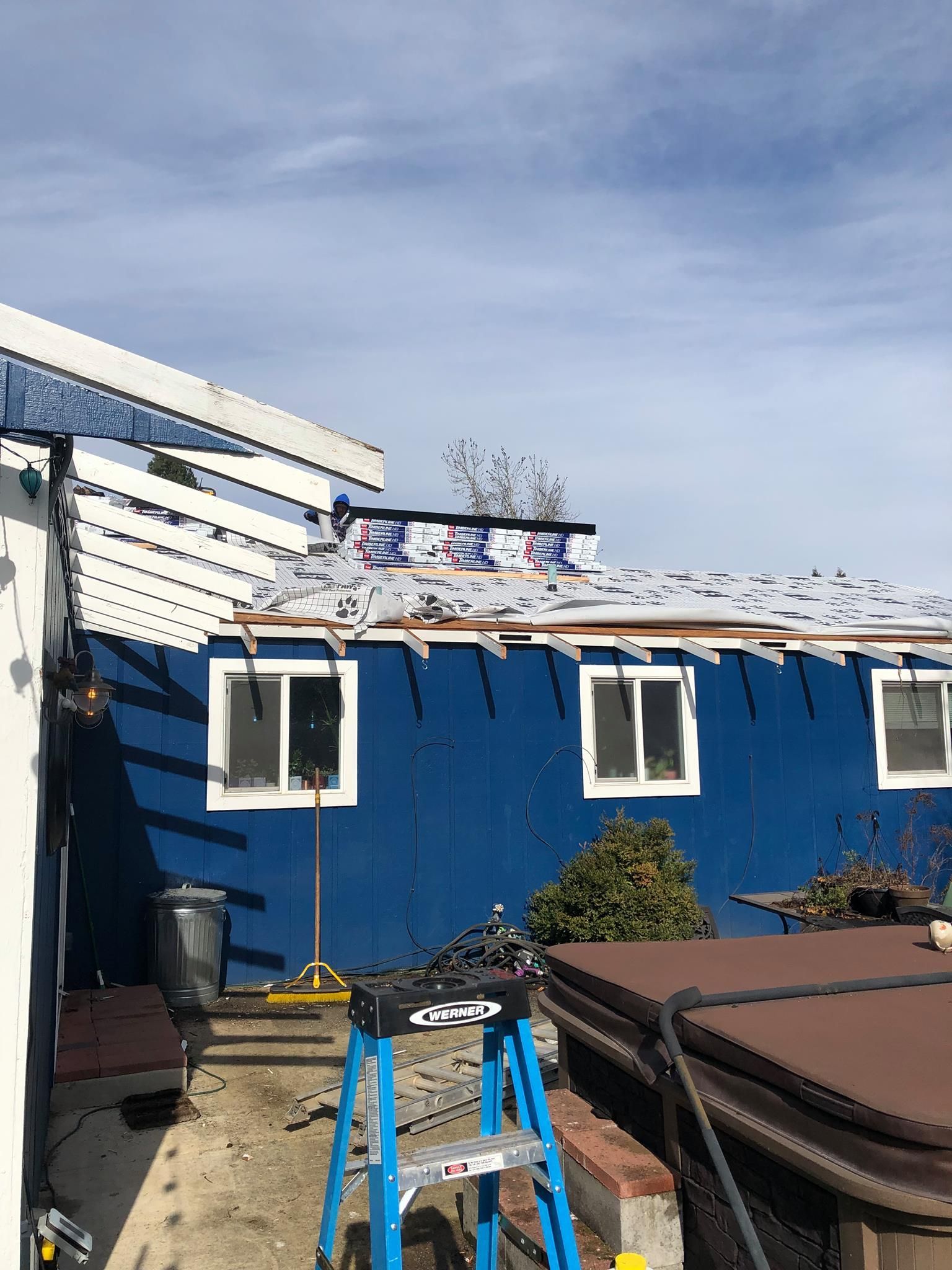 A blue house with a ladder in front of it.