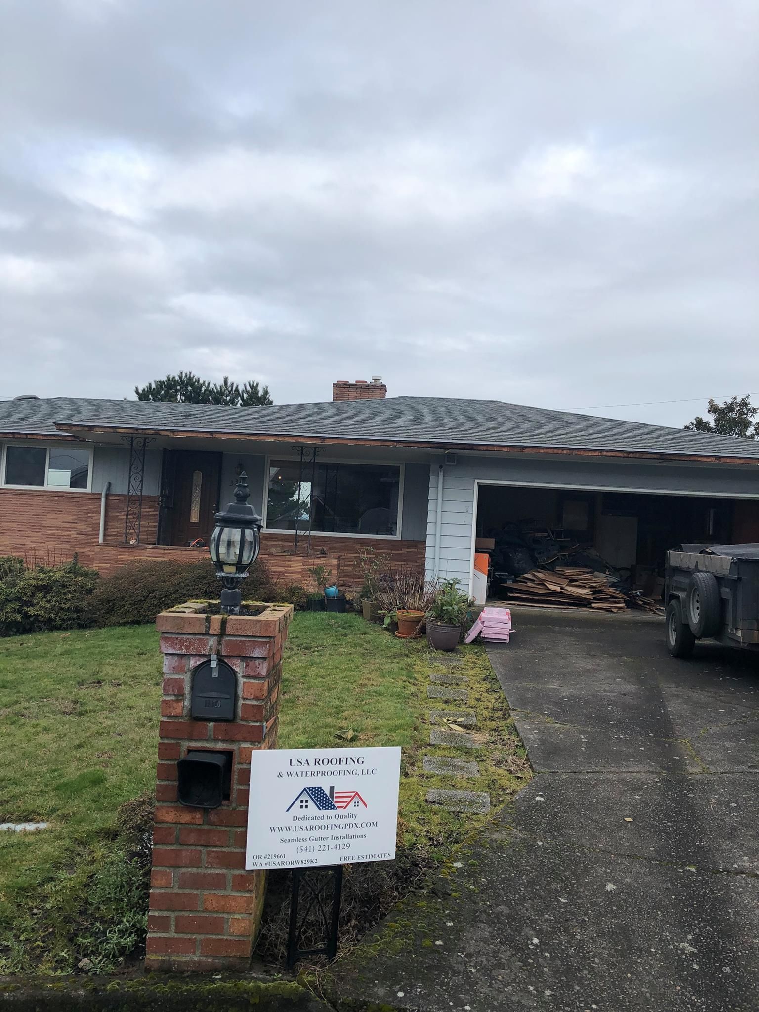 A house with a mailbox and a sign in front of it.