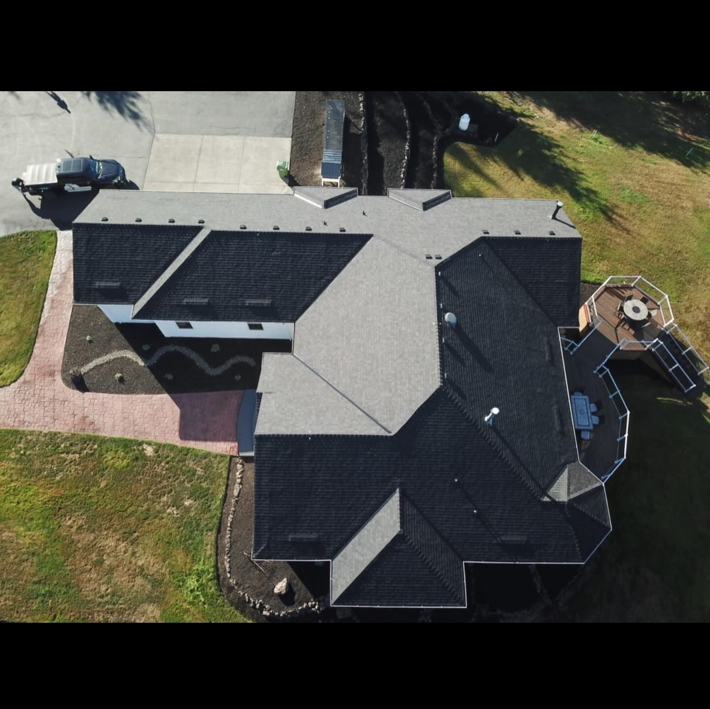 An aerial view of a house with a black roof.