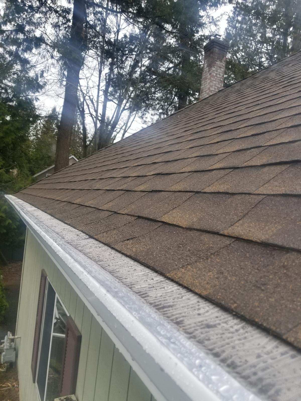 A house with a brown roof and a white gutter.