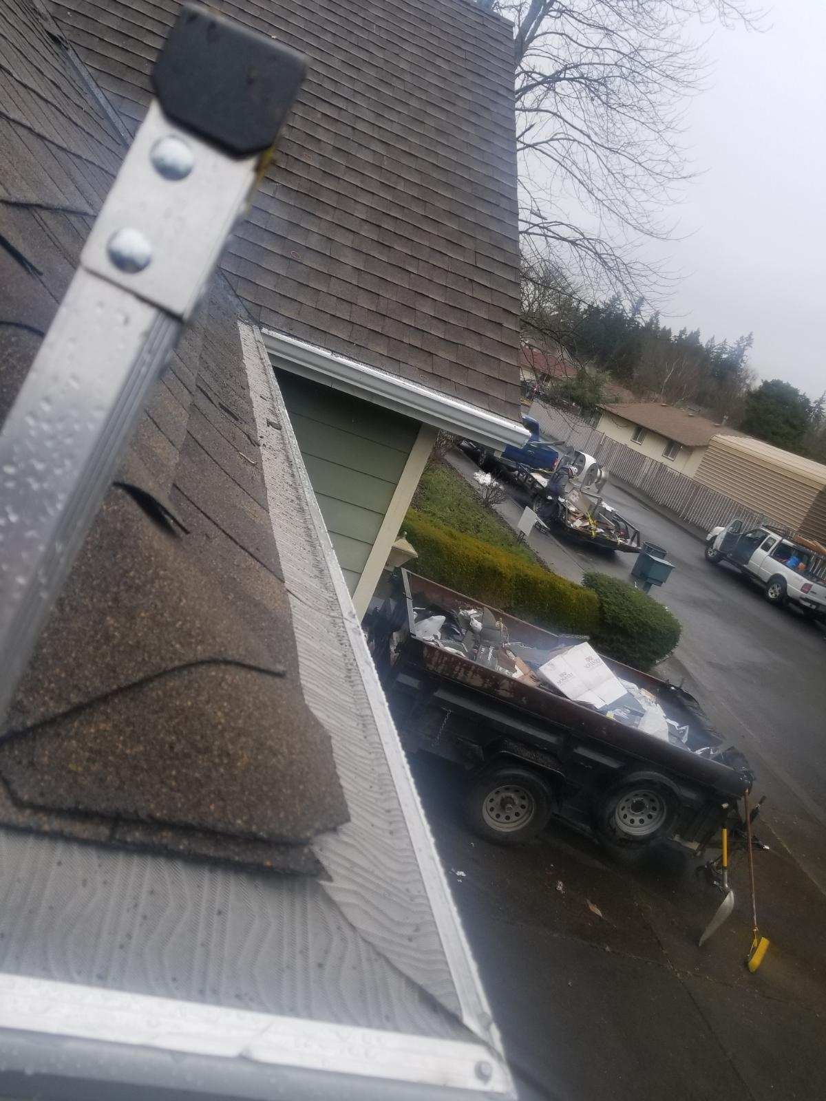 A ladder is sitting on top of a roof next to a house.