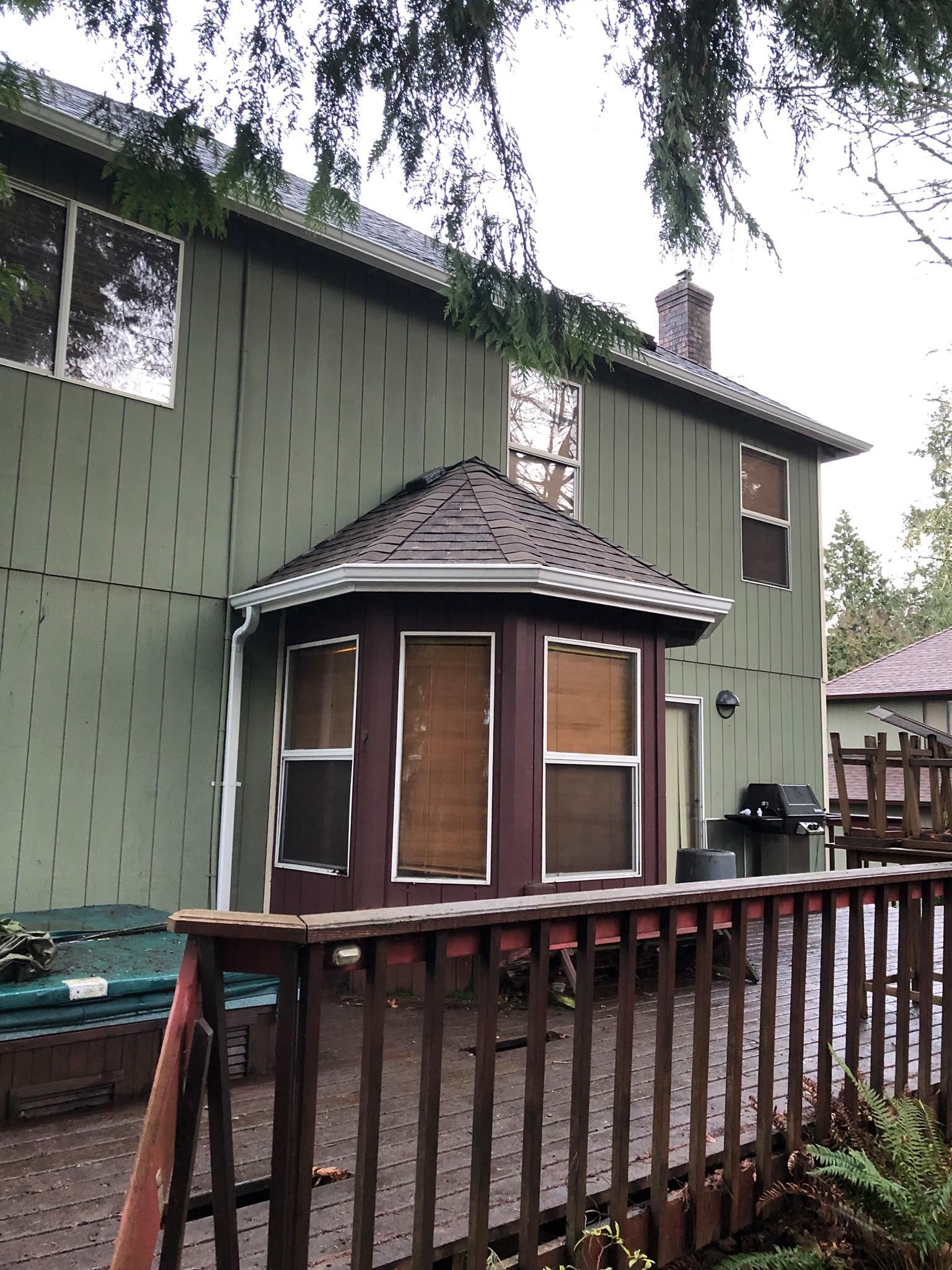 A green house with a wooden fence around it.