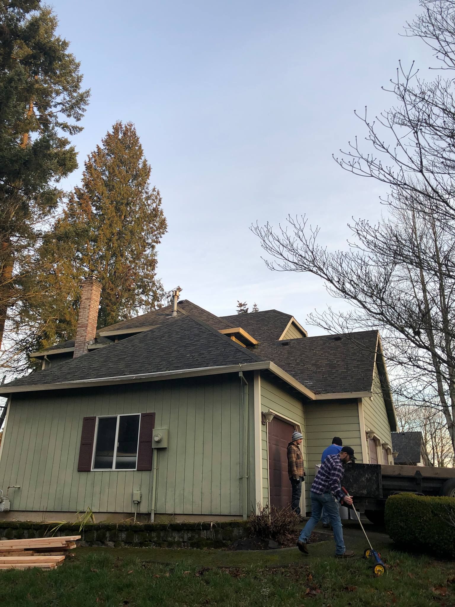 Two men are working on the roof of a house.