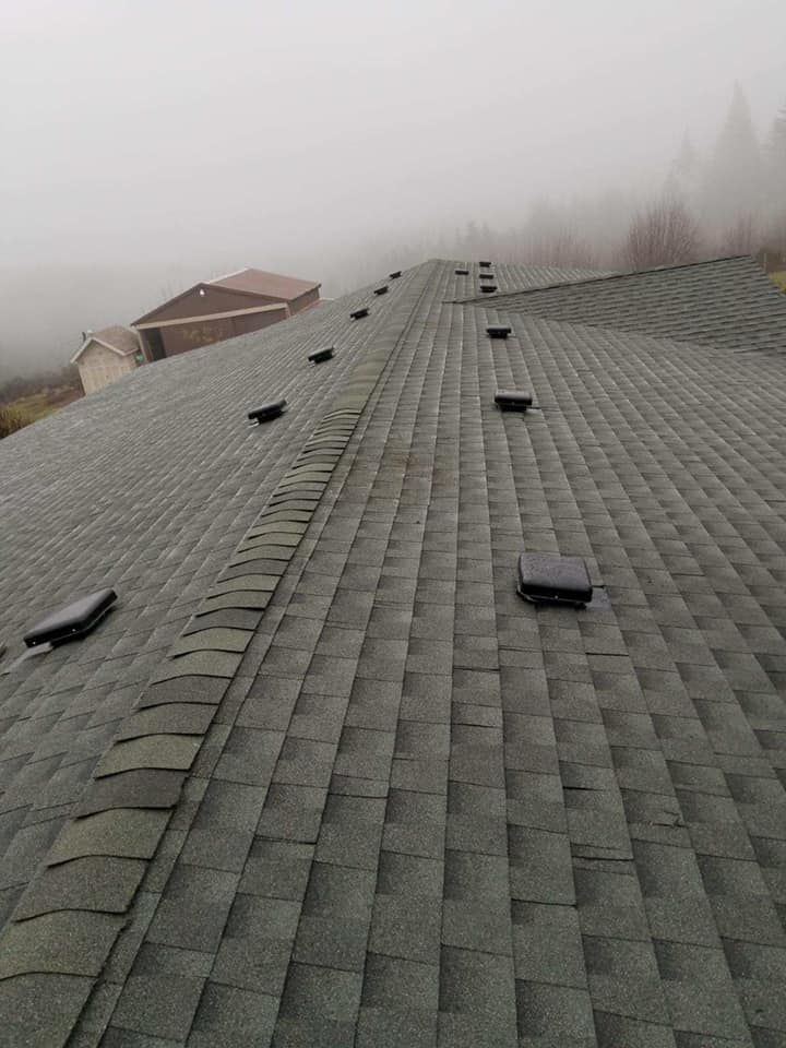 A roof with a lot of vents on it in the fog.