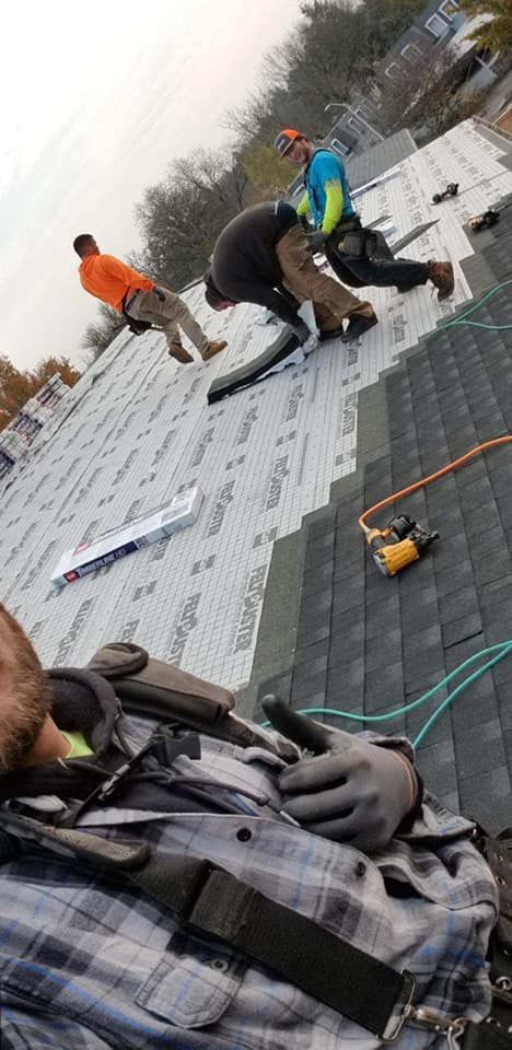 A group of men are working on a roof.