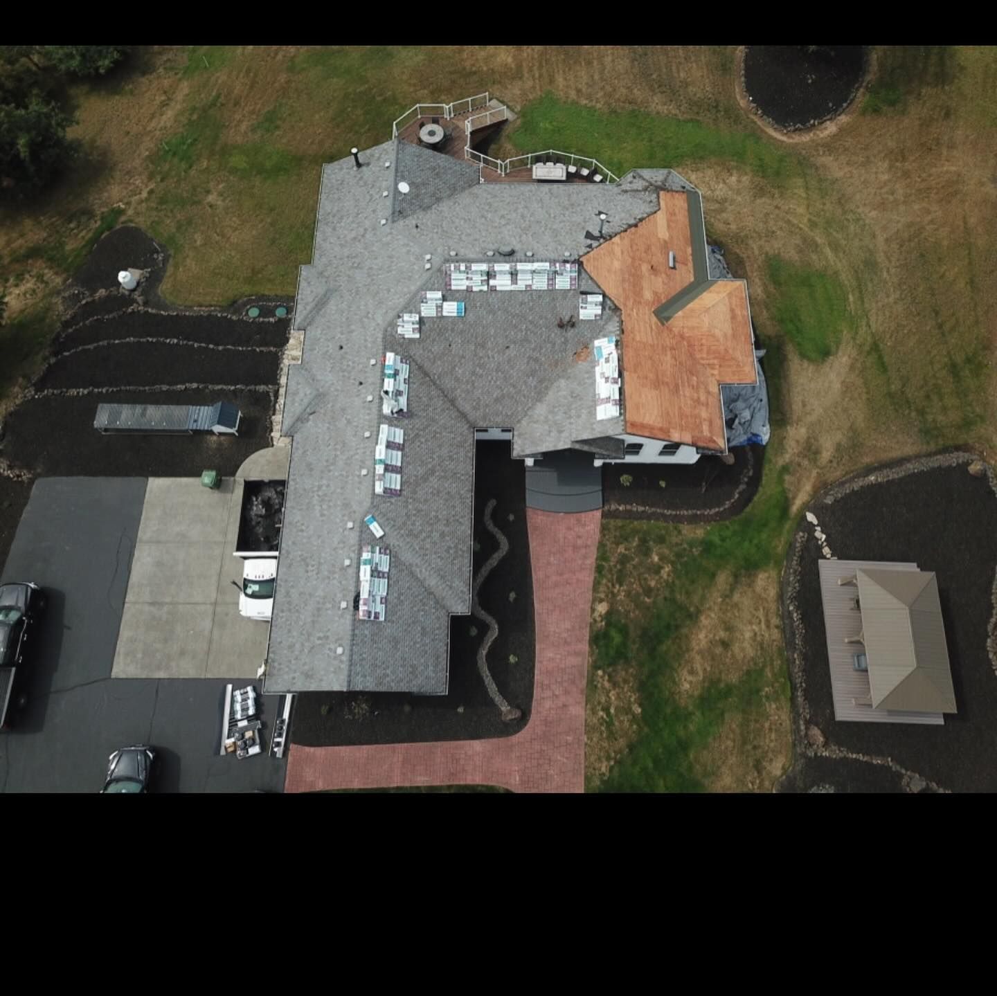 An aerial view of a large house with a lot of cars parked in front of it.