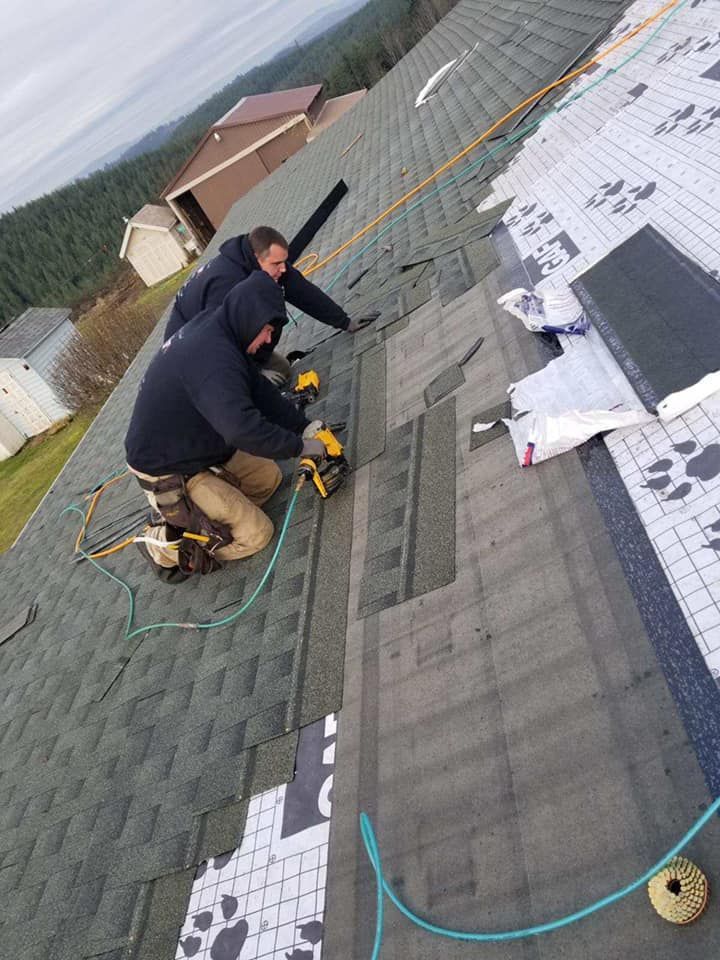Two men are working on the roof of a house.