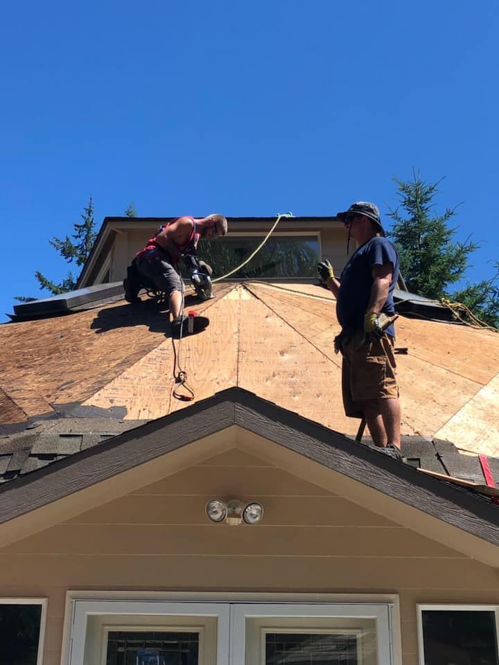 Two men are working on the roof of a house.