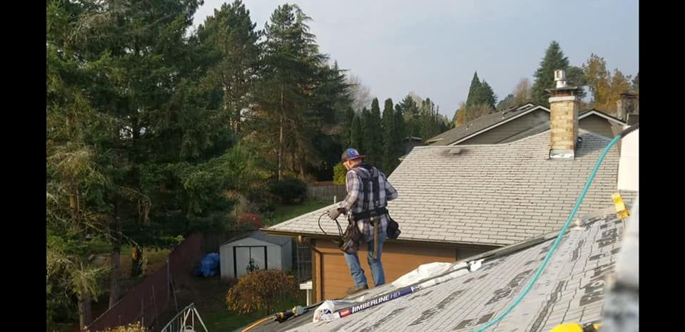 A man is standing on the roof of a house.