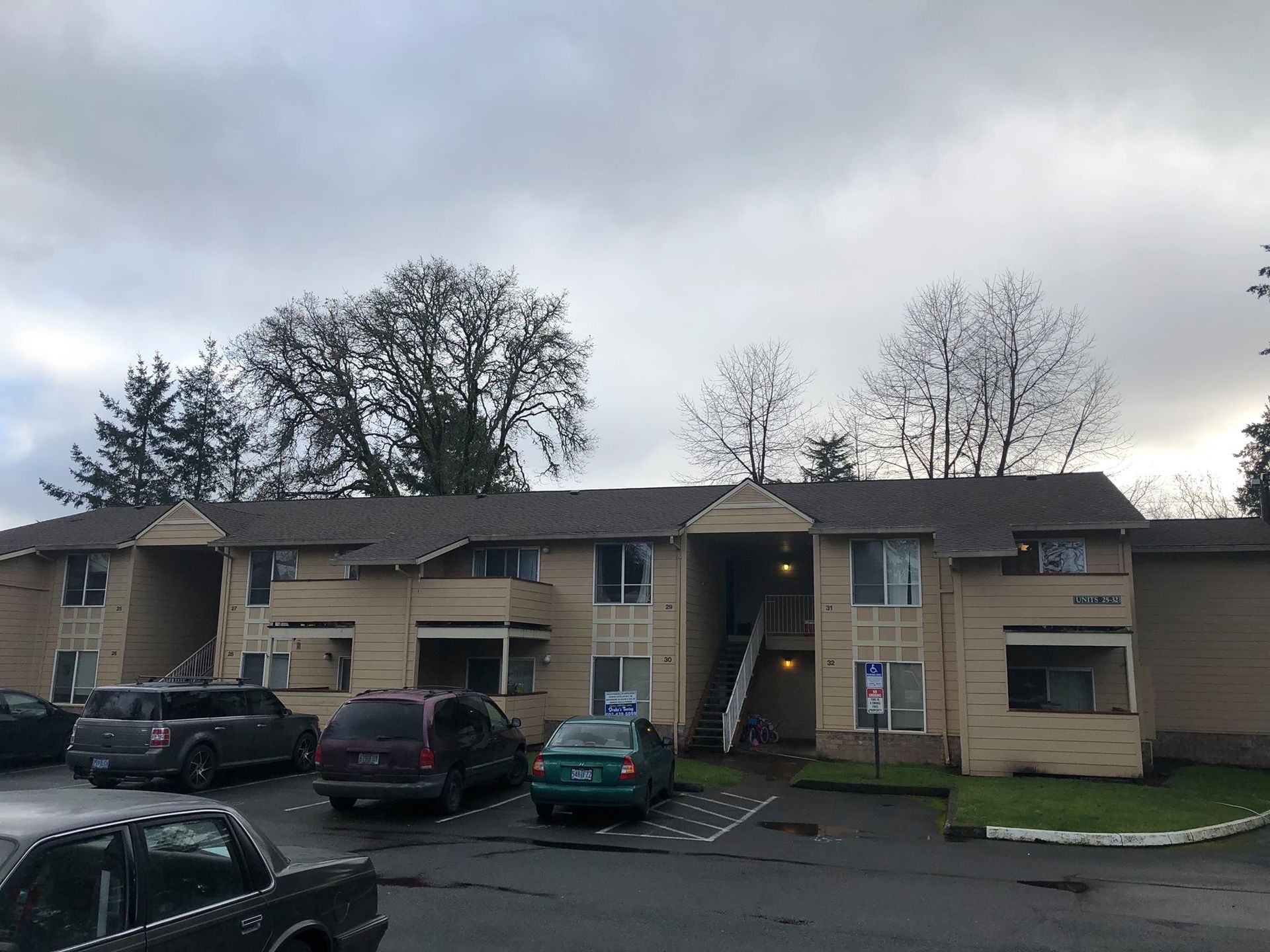 A large apartment building with cars parked in front of it.