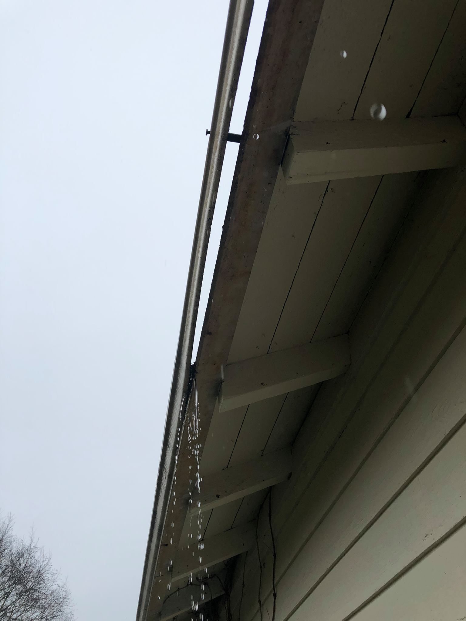 Rain is falling from the roof of a house.