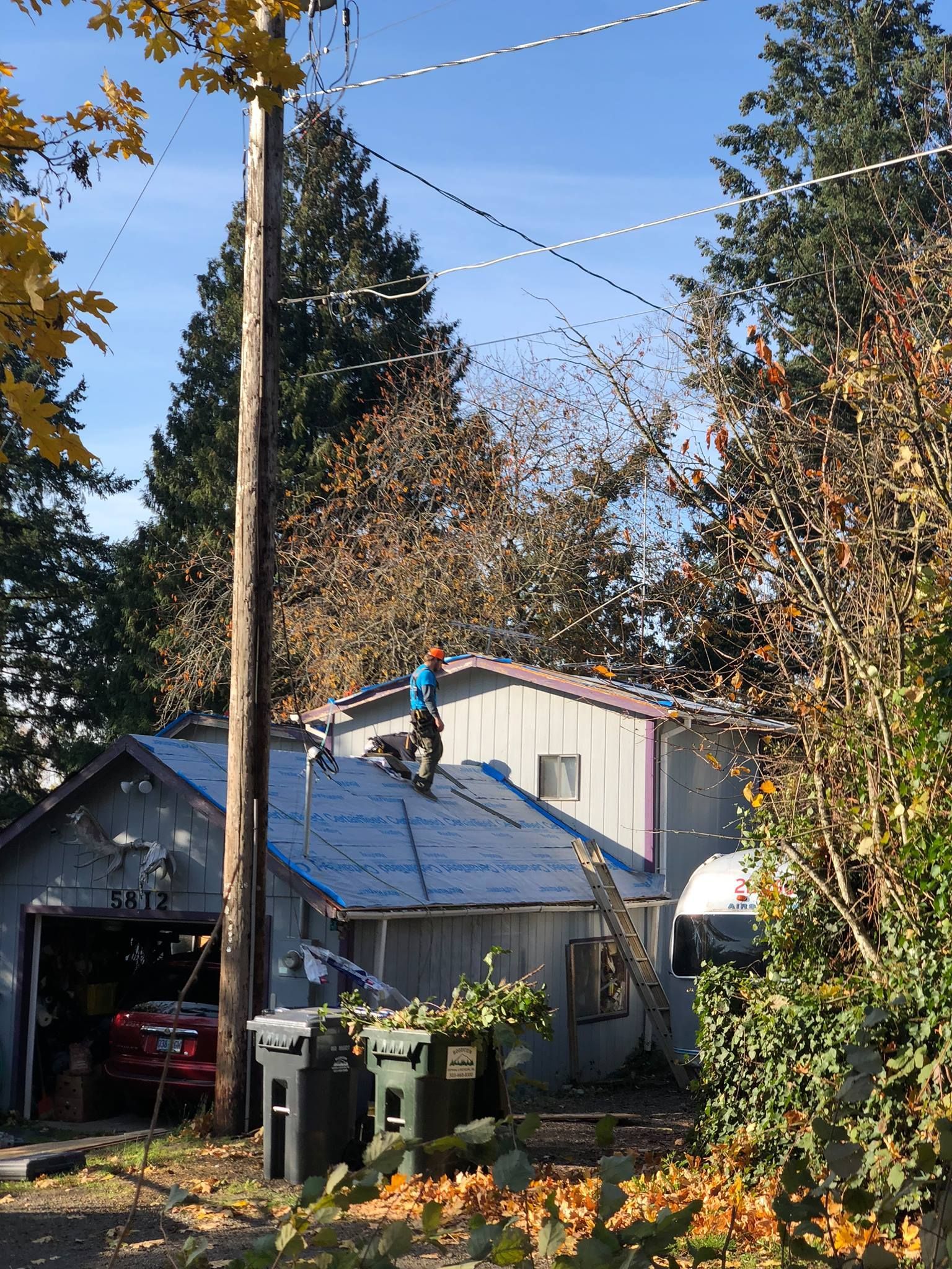 A man is working on the roof of a house.