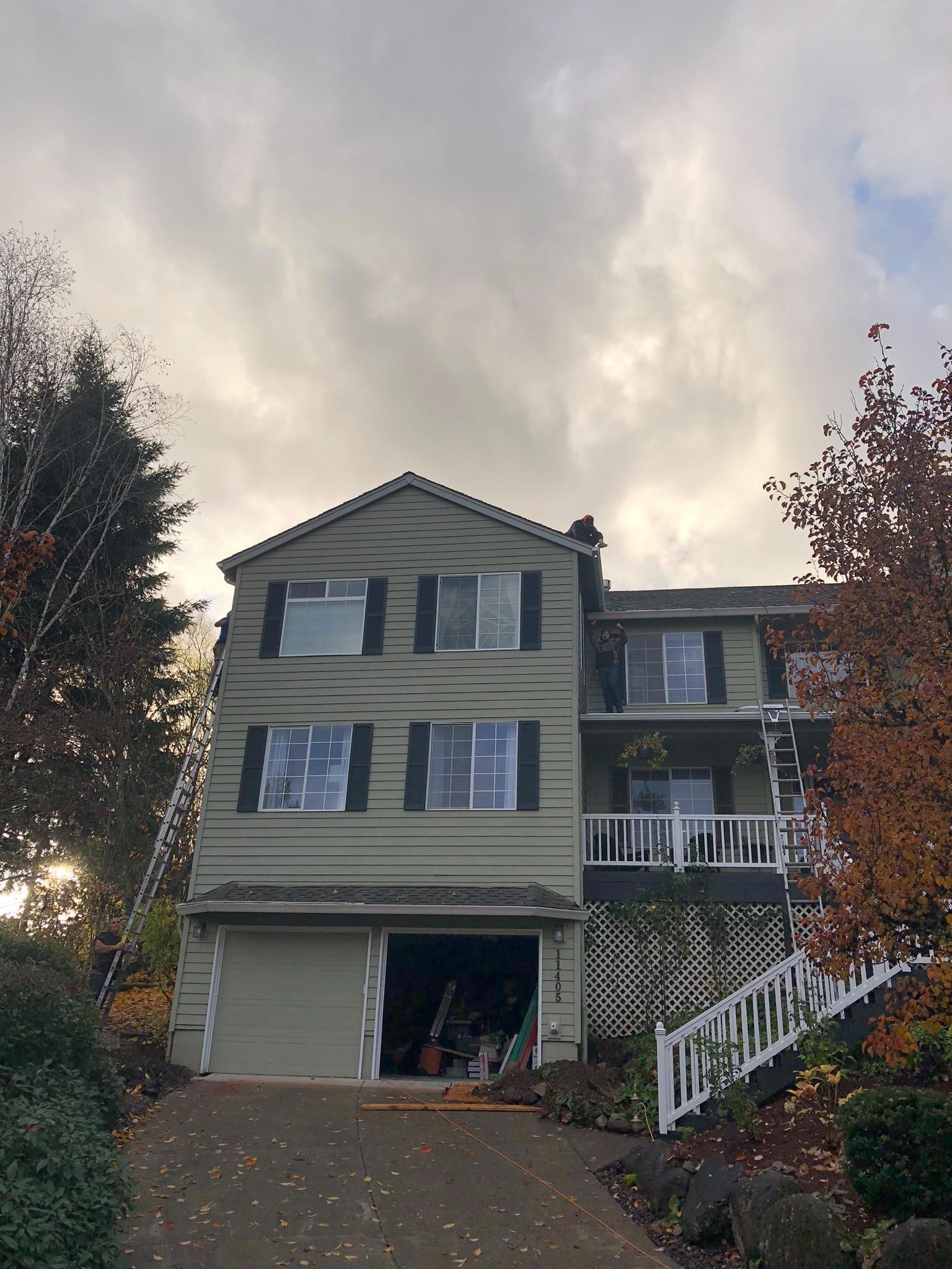 A large house with a garage and a ladder in front of it.