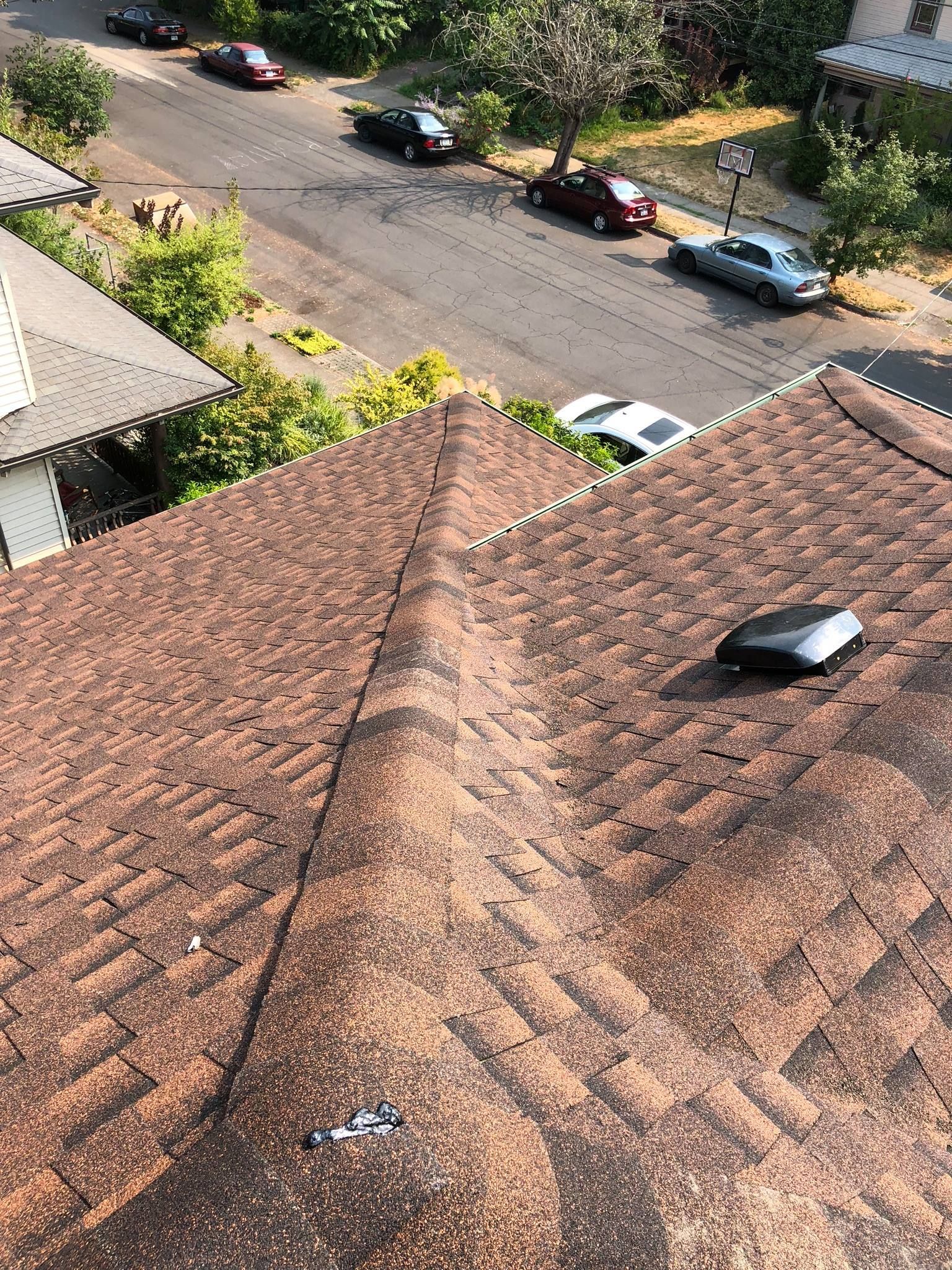 An aerial view of a roof with cars parked on the side of the road.