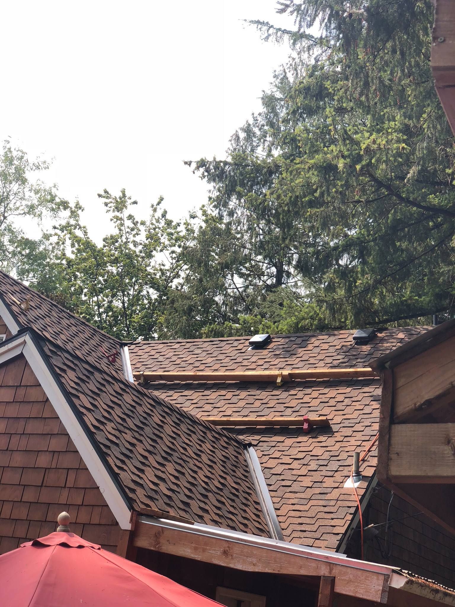 A roof with a red umbrella in front of it.