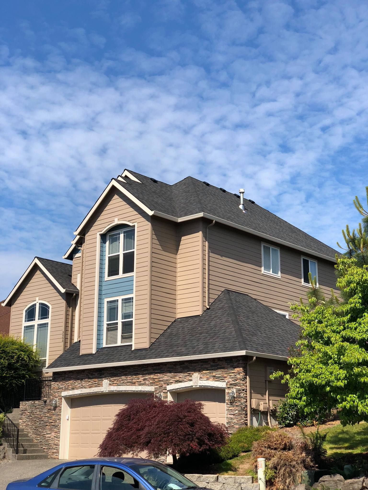 A large house with a car parked in front of it.