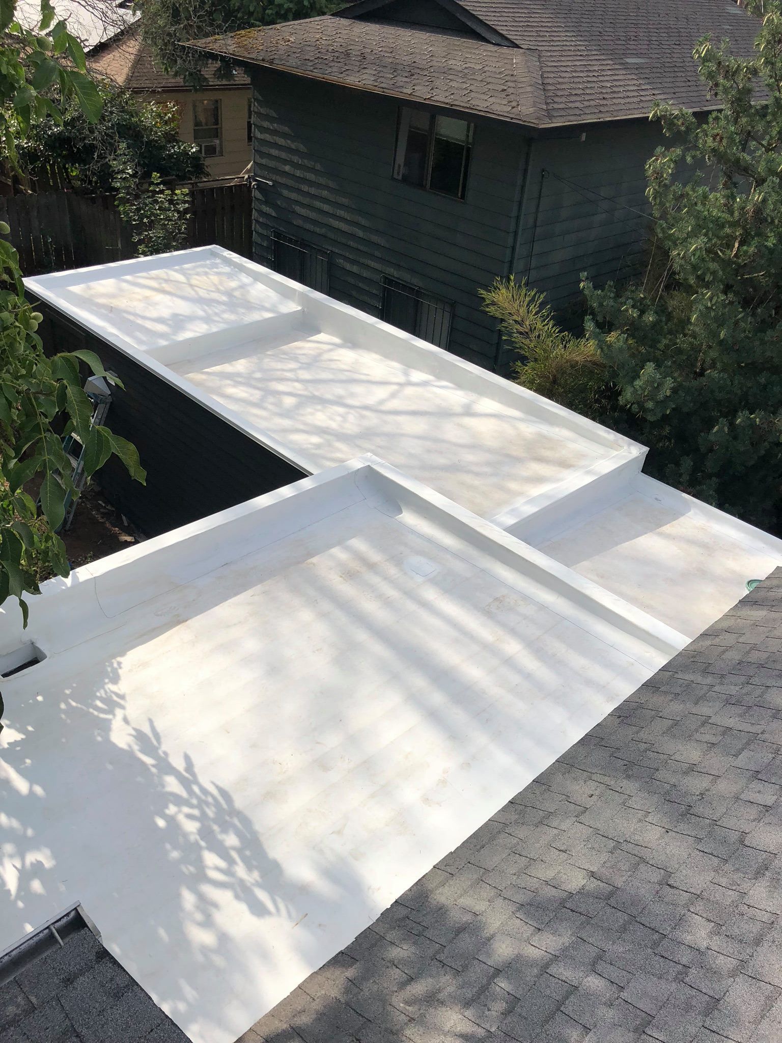 A white roof is sitting on top of a gray roof.