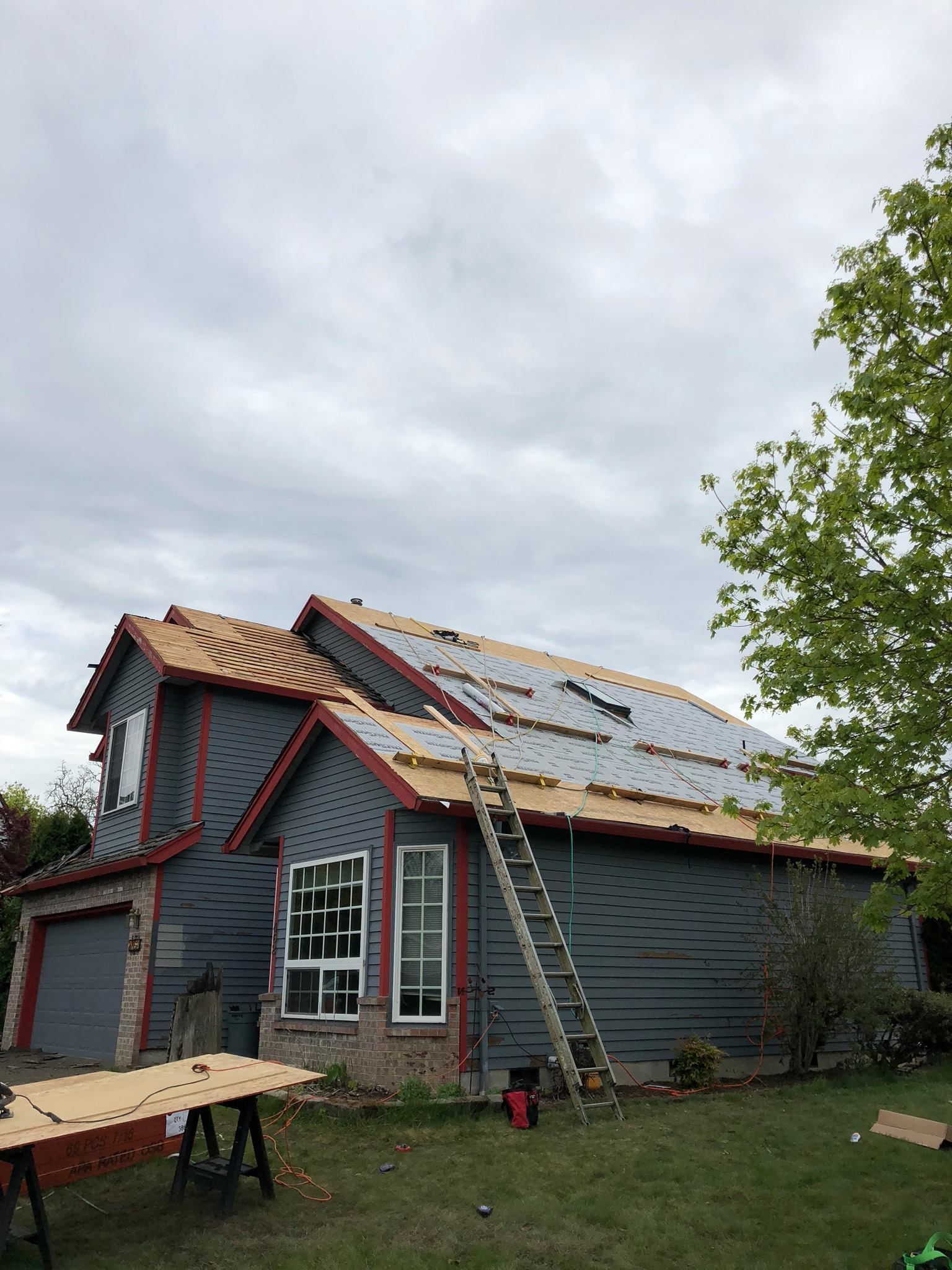 A house is being remodeled with a ladder on the roof.