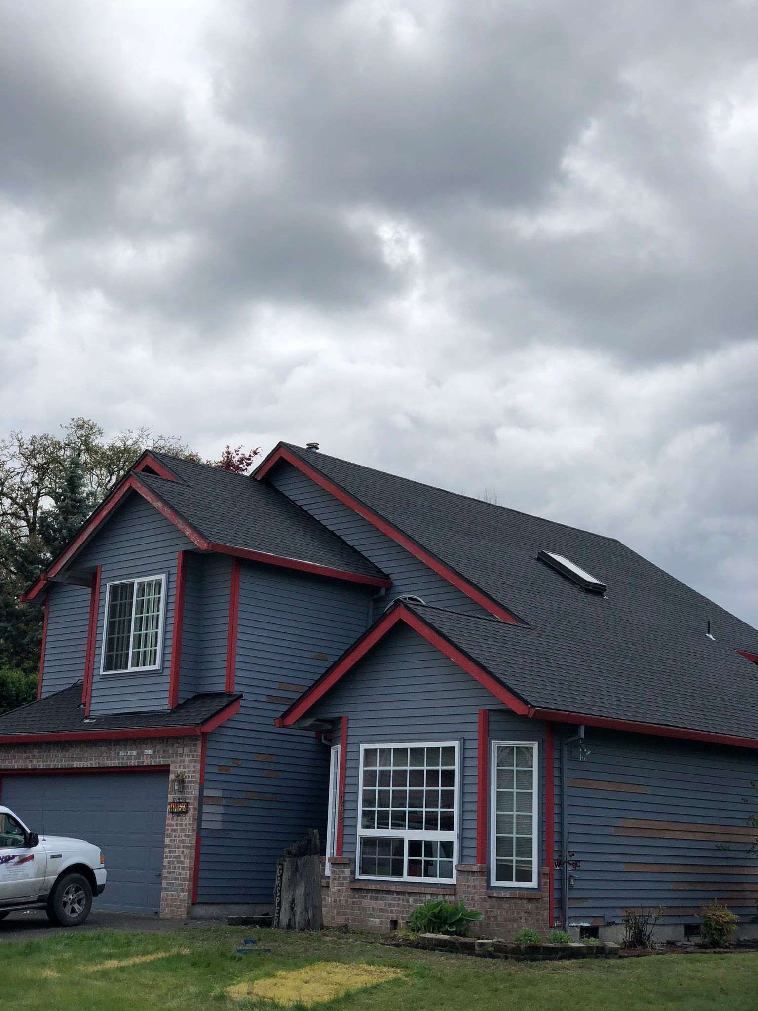 A blue house with a white truck parked in front of it.