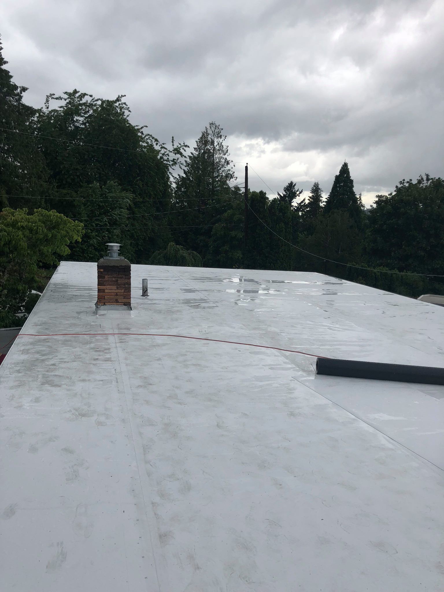 A white roof with a chimney on top of it.