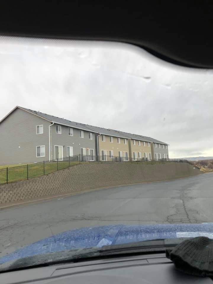 A car is driving down a road with a building in the background.
