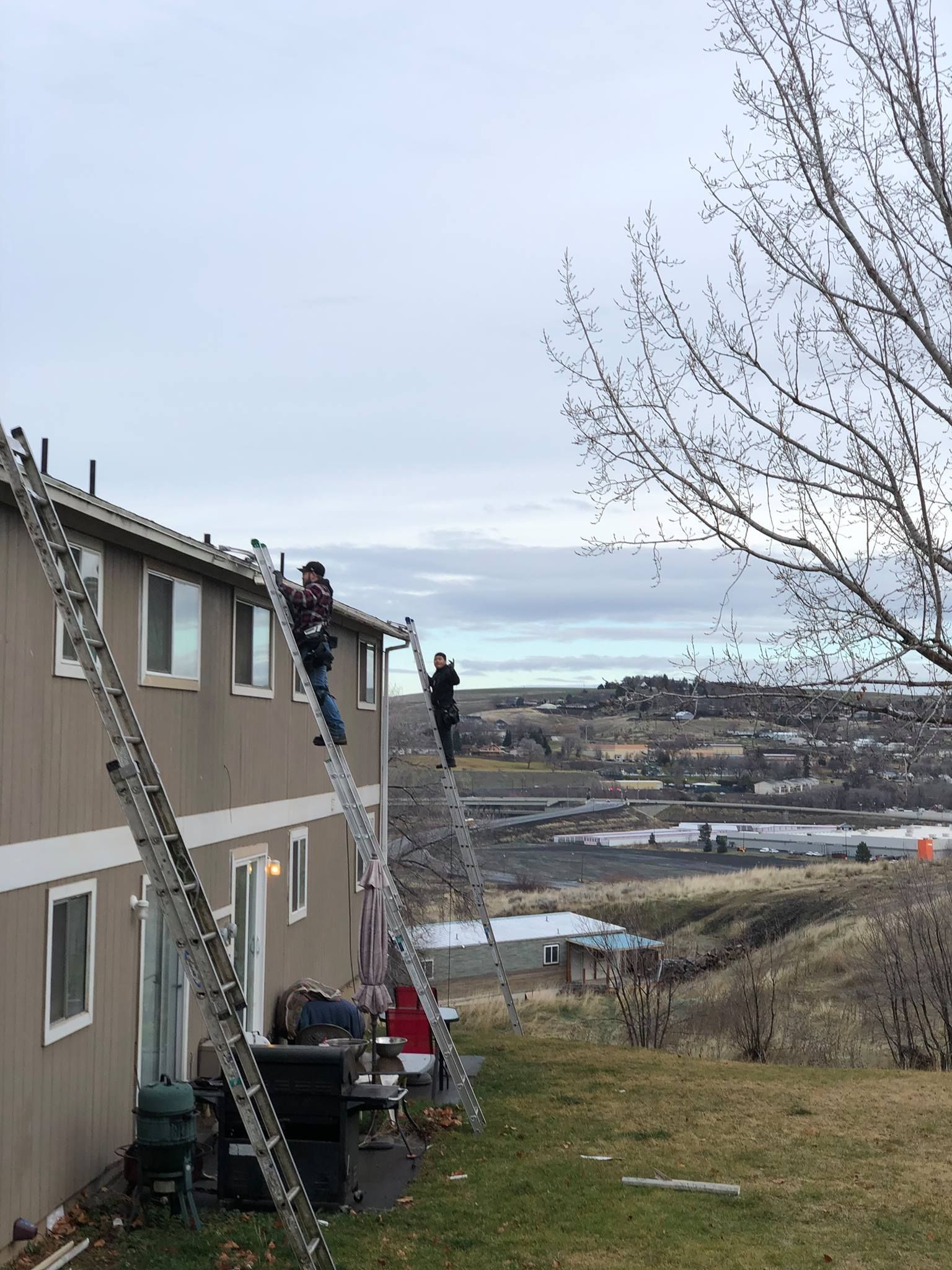 A group of people are working on the roof of a building.
