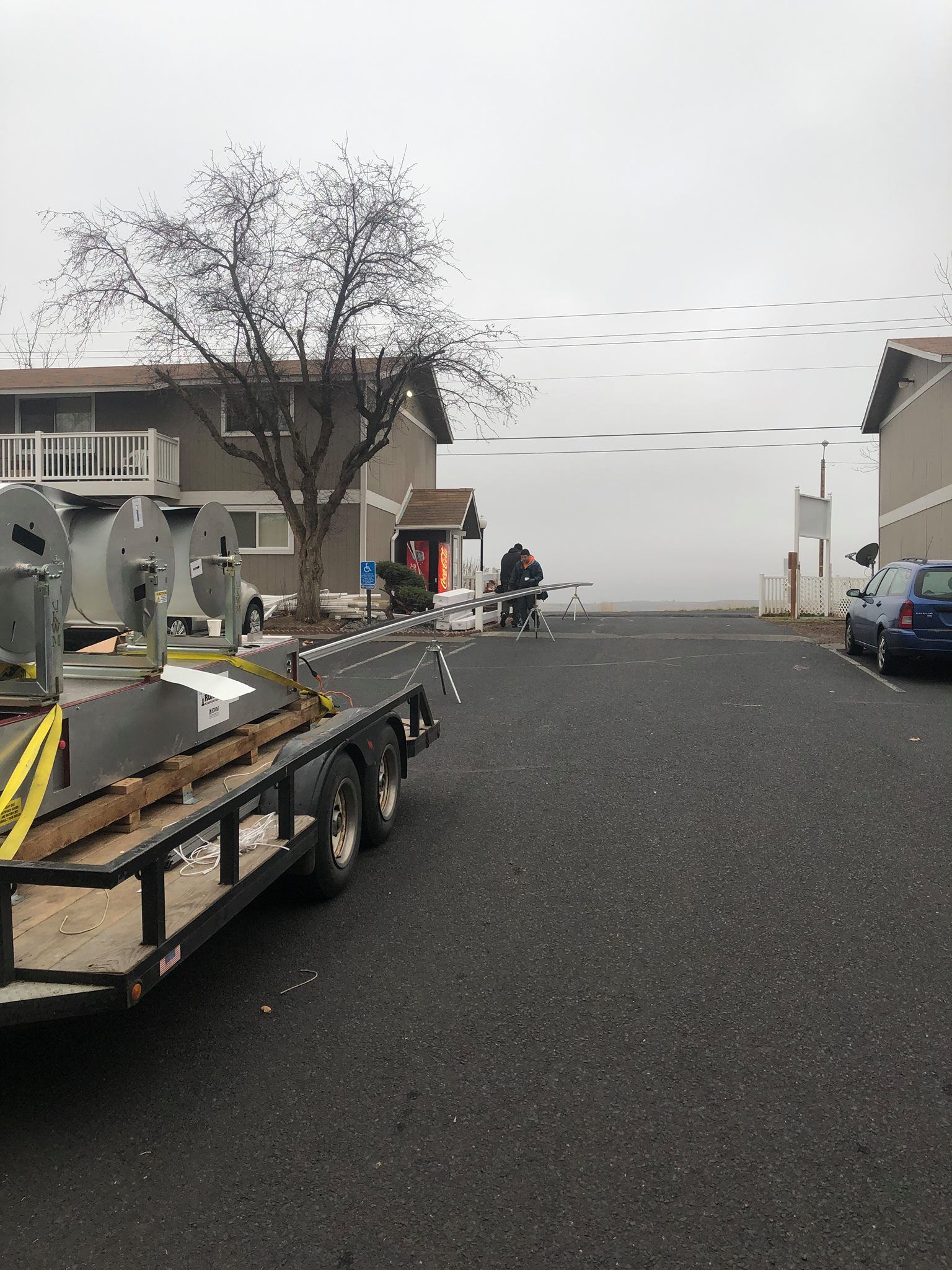 A trailer with a bunch of boxes on it is parked in a parking lot.