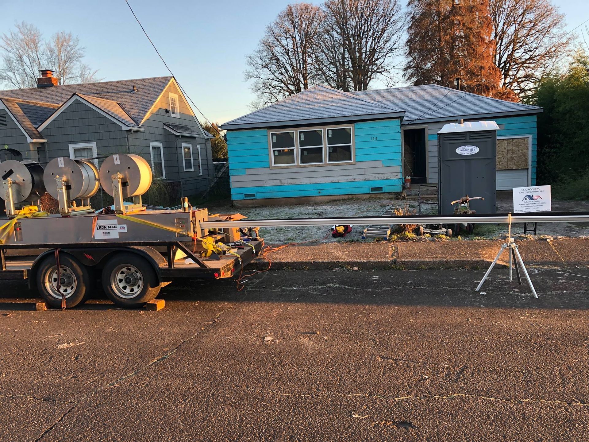 A trailer is parked in front of a house under construction.
