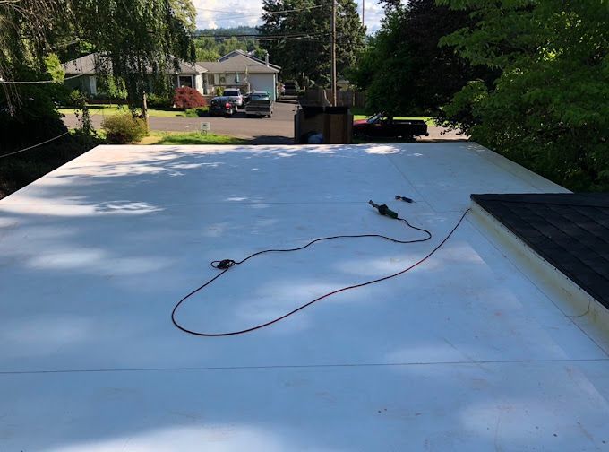 A white roof with a black roof and a cable on it.