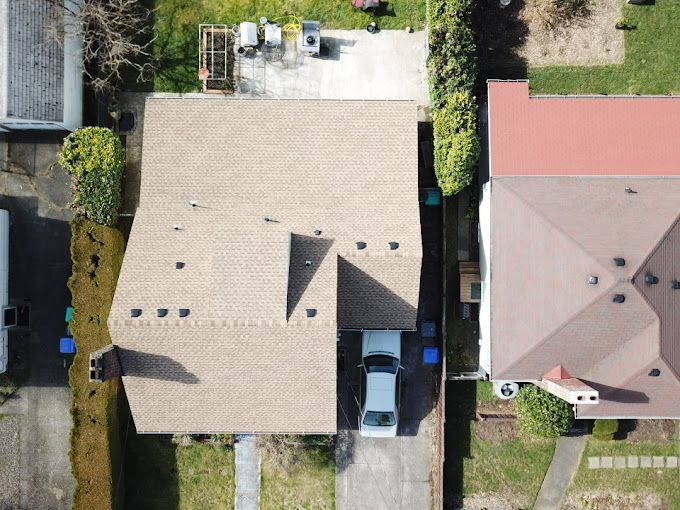 An aerial view of a house with a car parked in the driveway.