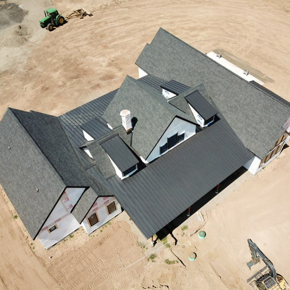 An aerial view of a house with a tractor in the background.