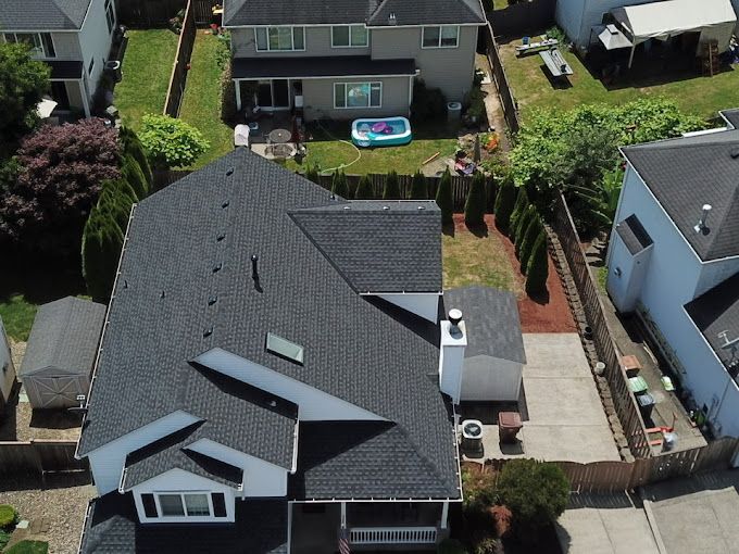 An aerial view of a house with a pool in the backyard.