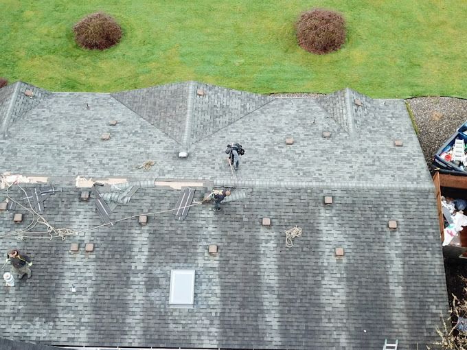 An aerial view of a house with a roof that is being repaired.