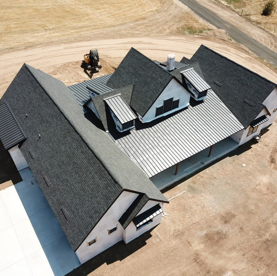 An aerial view of a house with a black roof.
