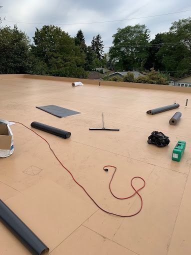 A roof with a red cord laying on it.