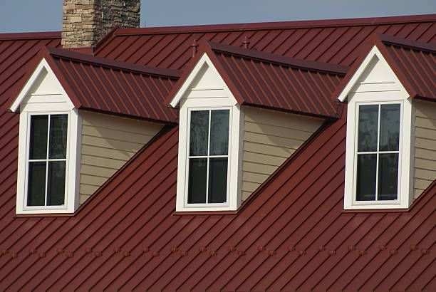 A red roof with three windows on it.