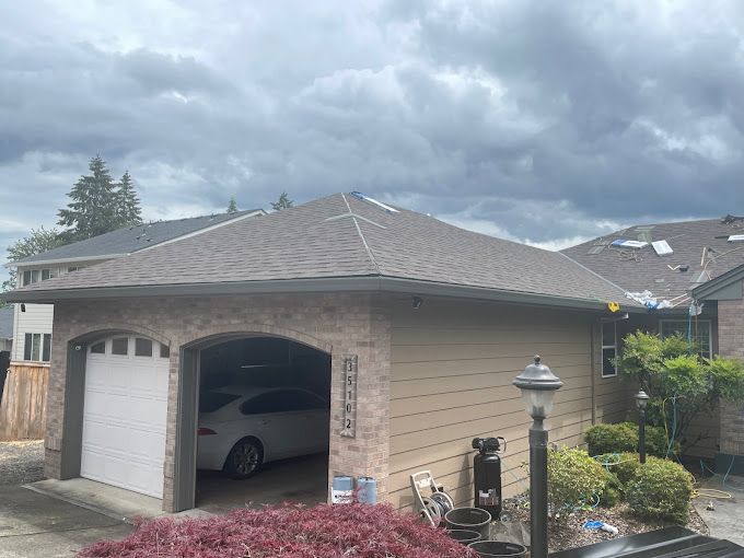 A car is parked in a garage under a cloudy sky.