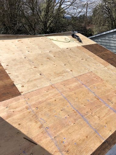 A wooden roof is being built on top of a house.